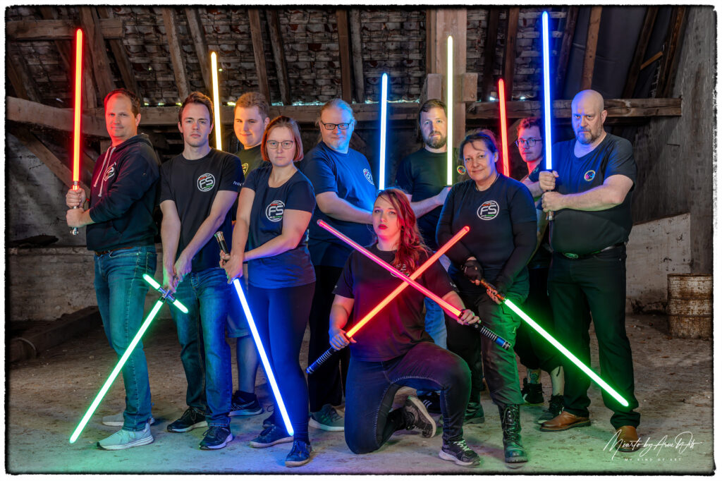 Gruppenfoto von Cosplayern mit Lichtschwertern in verschiedenen Farben â€“ Fan-Event mit starker Dynamik.