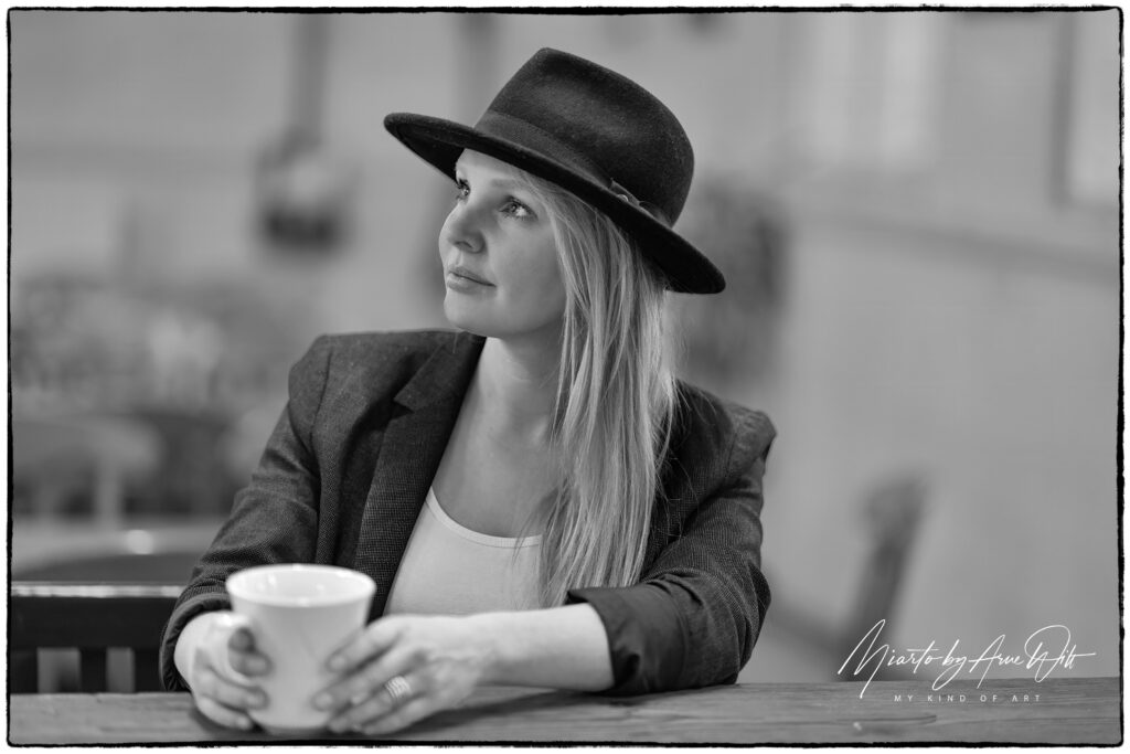 Retro-inspiriertes Porträt im Café mit Hut und Heißgetränk