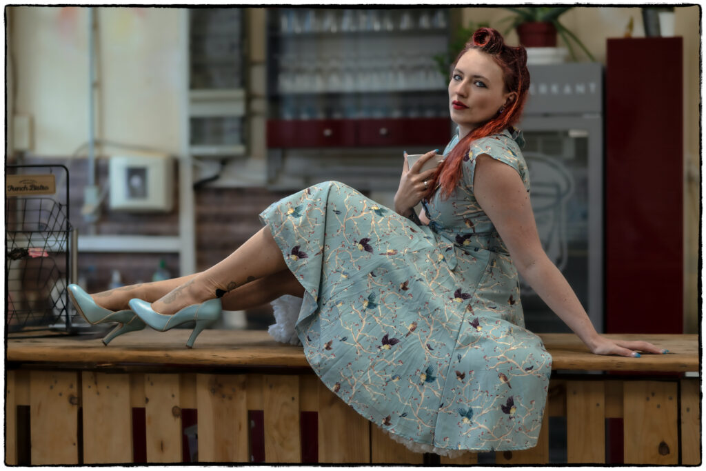 Frau mit Schleife sitzt elegant auf Kneipentresen, lebendiger Retro-Ausdruck