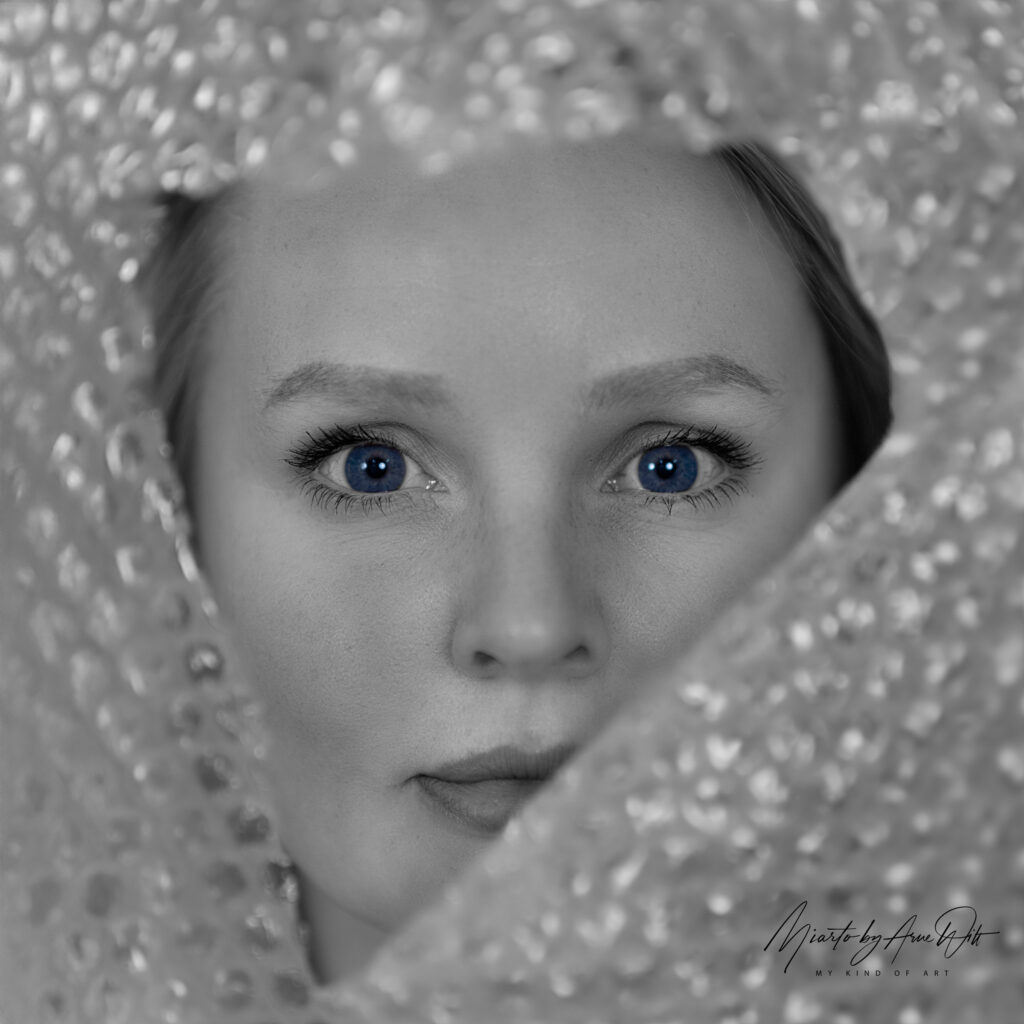 Intensiver Blick durch Folie, blaue Augen im Fokus, kreative Schwarz-Weiß-Aufnahme